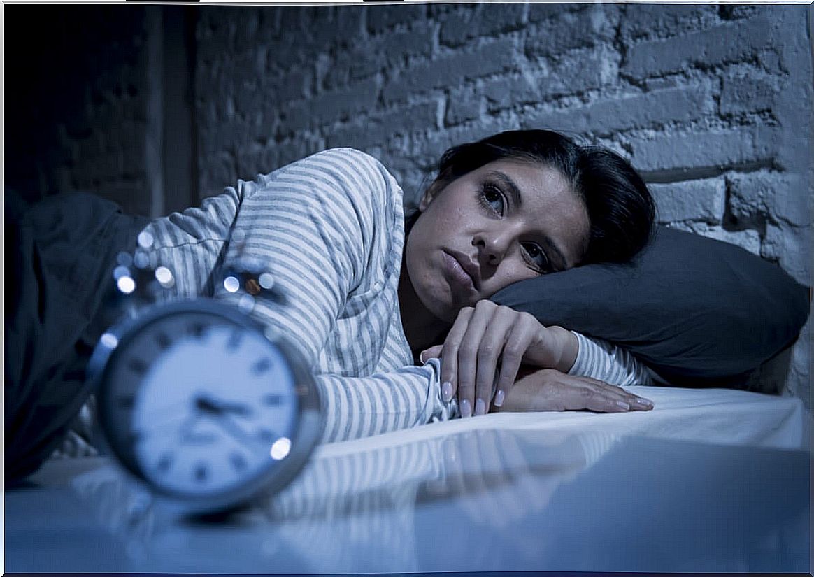 Woman with insomnia and clock.