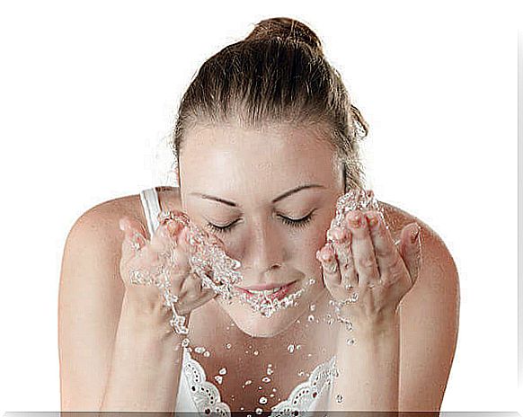 Girl cleaning her face with pure water