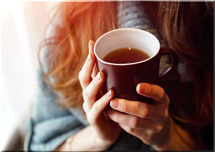 Woman holding cup of tea