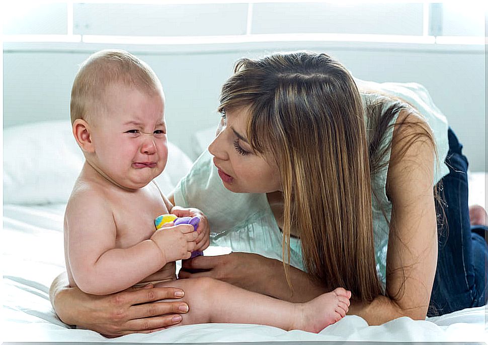 A mother tending to her crying baby.