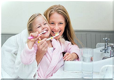 Mother and daughter brushing their teeth: good oral hygiene in children